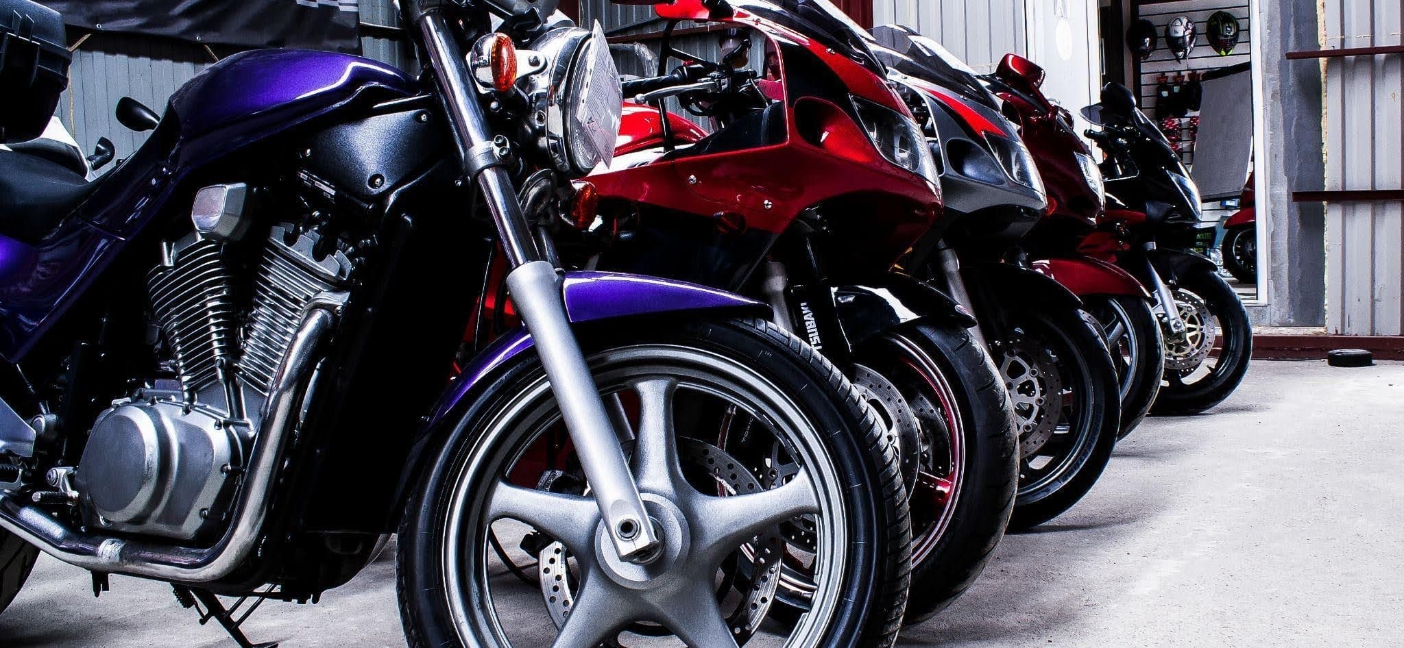 A row of parked motorcycles lined up neatly on a street